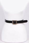 Black belt with a gold buckle on a white mannequin.