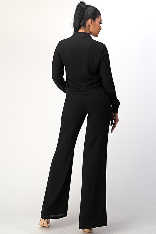 Woman wearing a black outfit with wide-leg pants on a white background