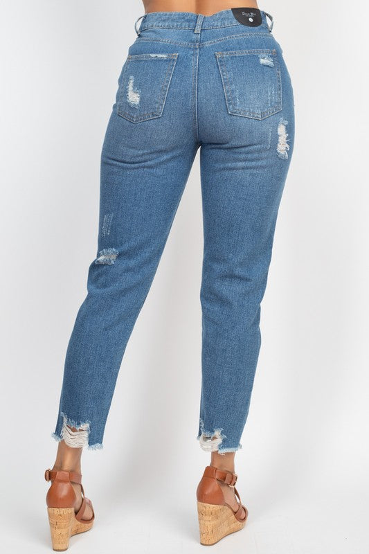 Blue jeans with distressed details on a white background