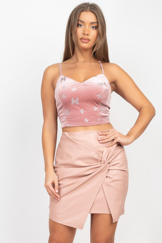 Woman wearing a pink and white crop top with a matching skirt on a white background