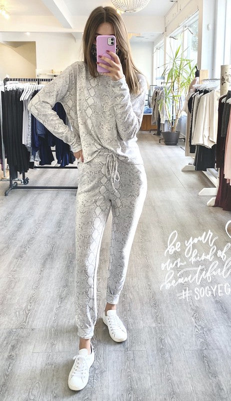 Person wearing a gray tracksuit in a clothing store.