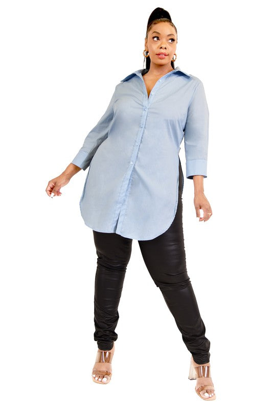 Woman wearing a light blue button-up shirt and black pants on a white background