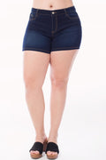 Person wearing dark blue denim shorts on a white background