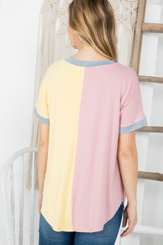 Woman wearing a pastel color-blocked t-shirt with a white background