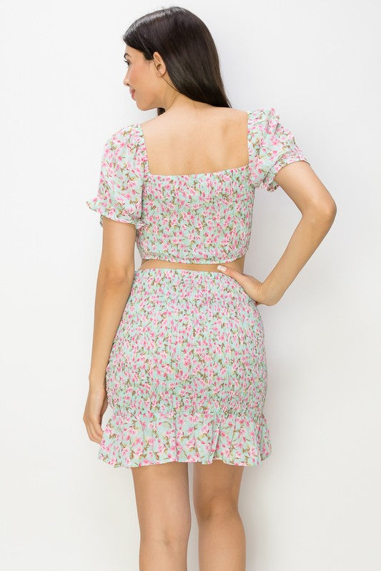 Woman wearing a floral two-piece outfit against a white background