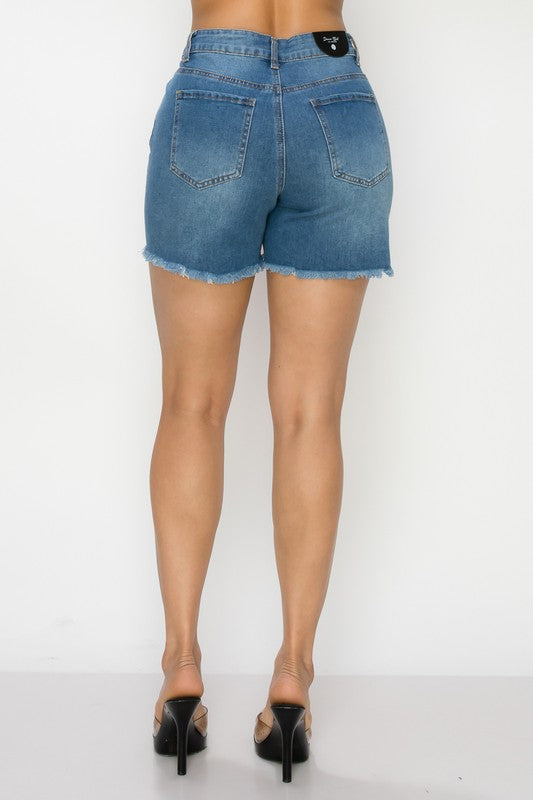 Blue denim shorts worn by a person on a white background