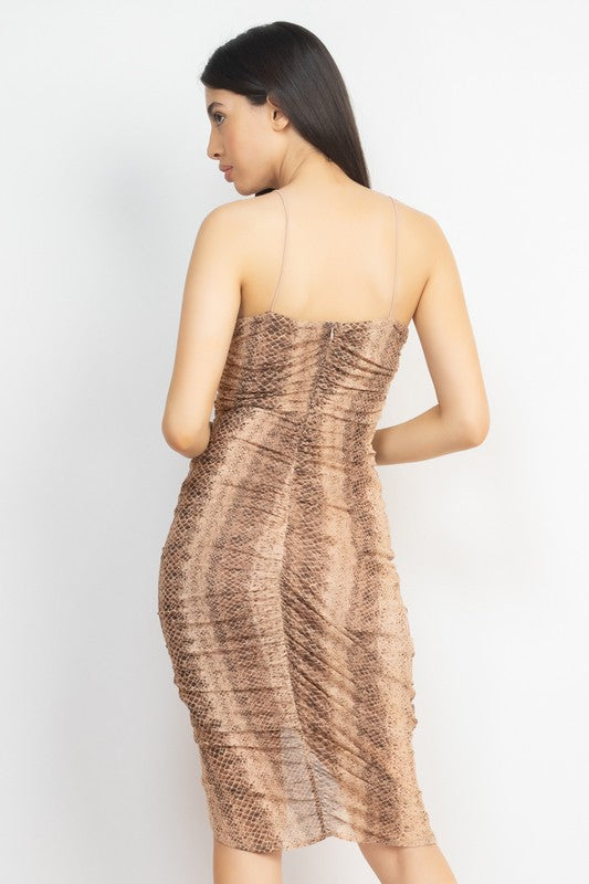 Woman wearing a patterned dress on a white background turning her back. 