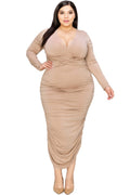 Woman wearing a beige ruched dress on a white background