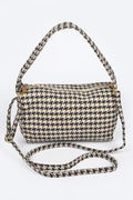 Houndstooth patterned handbag with a strap on a white background