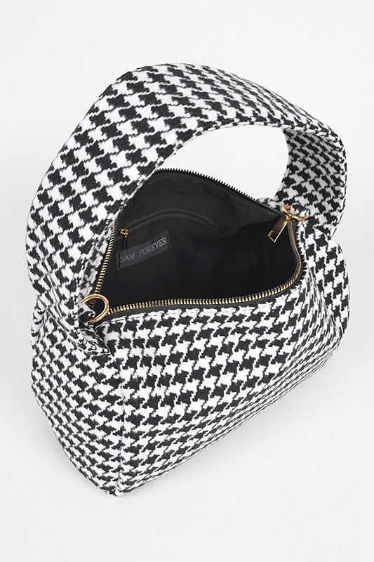 Black and white houndstooth patterned bag with open zipper on a white background