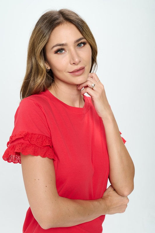 Woman wearing a red blouse with ruffled sleeves on a white background
