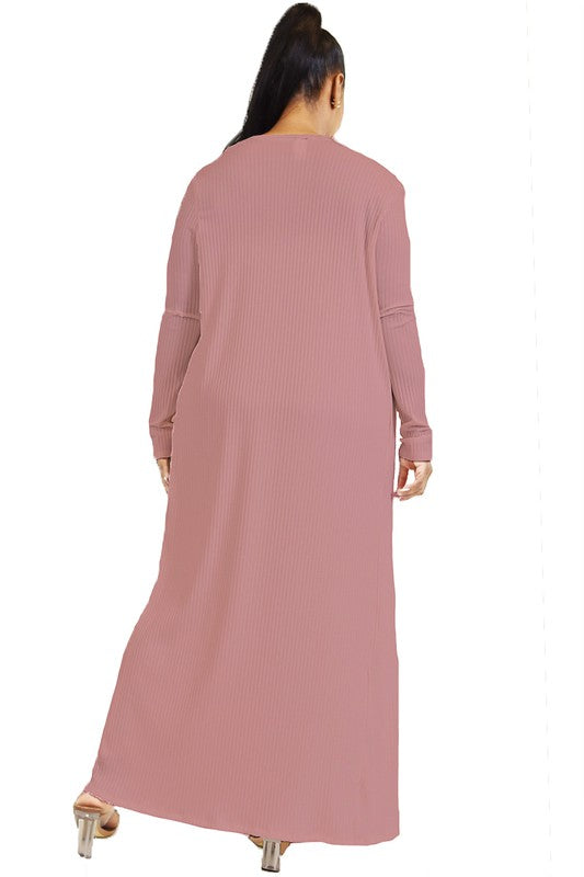 Woman wearing a long pink ribbed dress on a white background