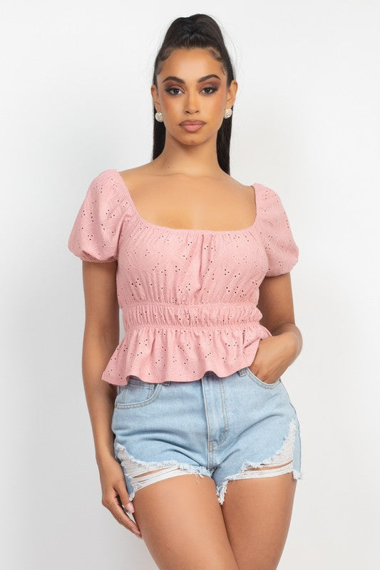 Woman wearing a pink top and denim shorts on a white background