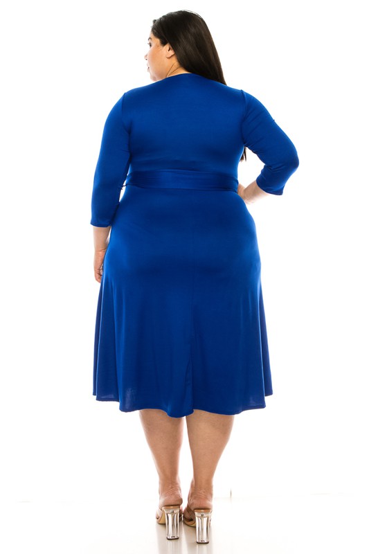 Woman wearing a blue dress with a belt on a white background