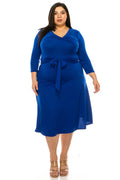 Woman wearing a blue dress with a belt on a white background