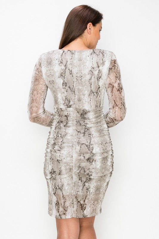 Woman wearing a snake print dress on a white background
