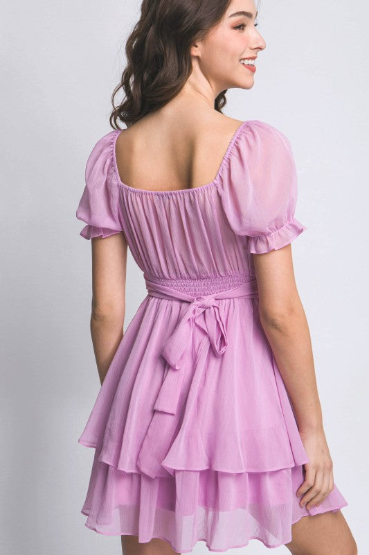 Woman wearing a pink dress with a plain background