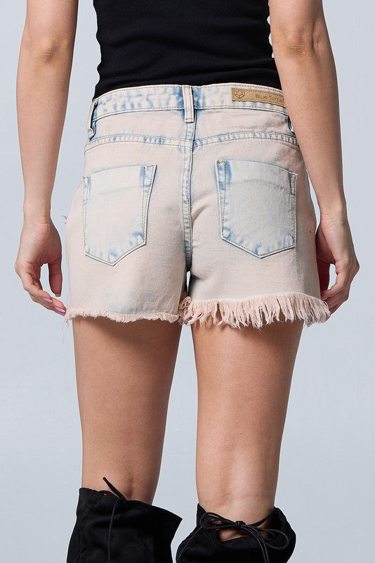 Denim shorts worn by a person on a plain background