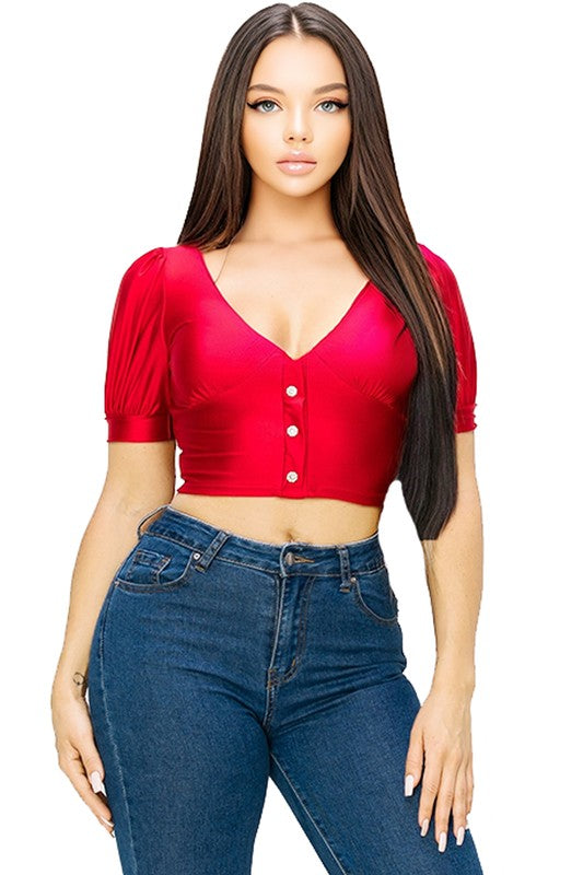 Woman wearing a red crop top and blue jeans on a white background