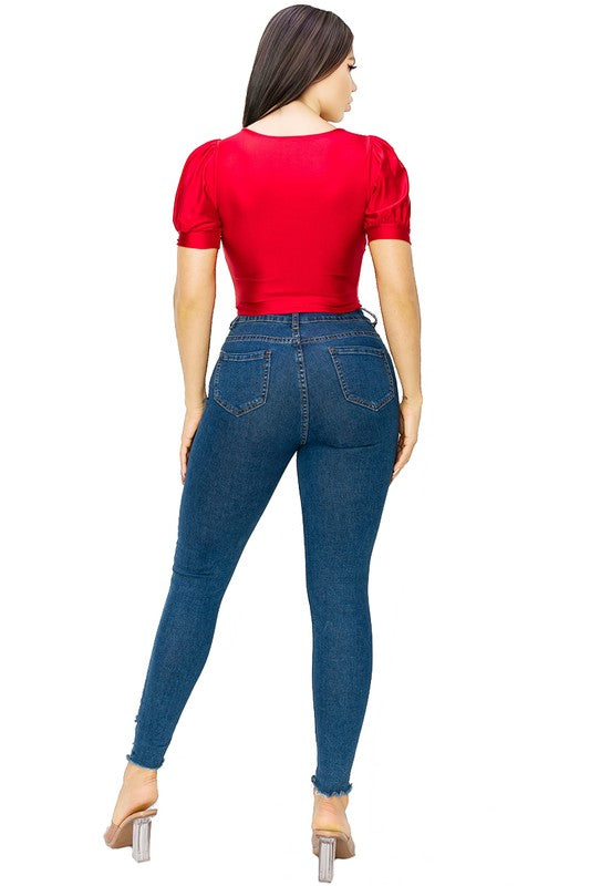 Woman wearing a red top and blue jeans on a white background