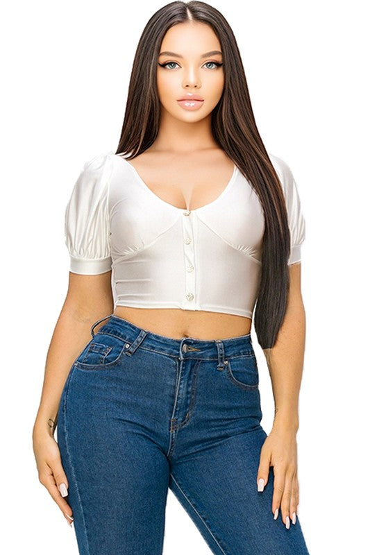 Woman wearing a white crop top and blue jeans on a white background
