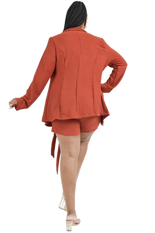 Person wearing a rust-colored outfit with a jacket and shorts on a white background