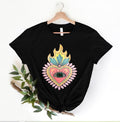 Black t-shirt with colorful heart design on a hanger