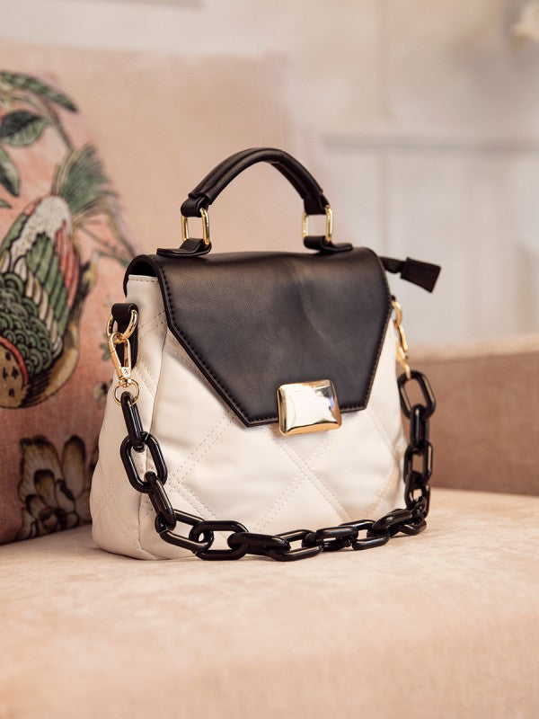 Black and white handbag with gold accents on a neutral background