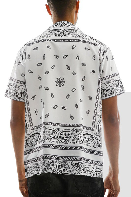 Person wearing a white shirt with black paisley pattern on a white background