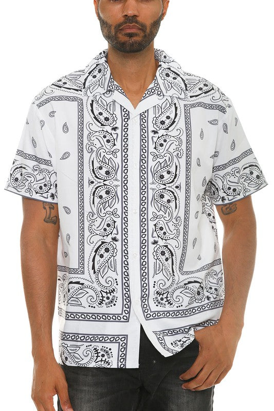 Man wearing a white shirt with black paisley pattern on a white background