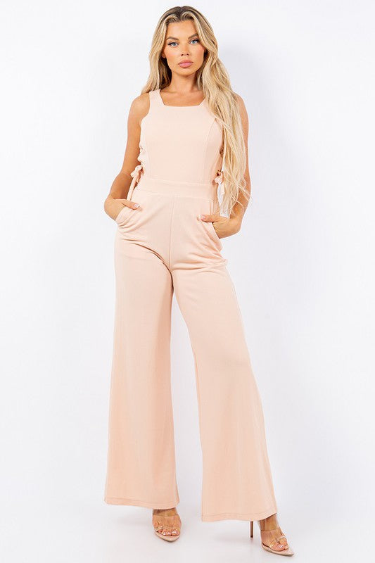 Woman wearing a beige jumpsuit on a white background