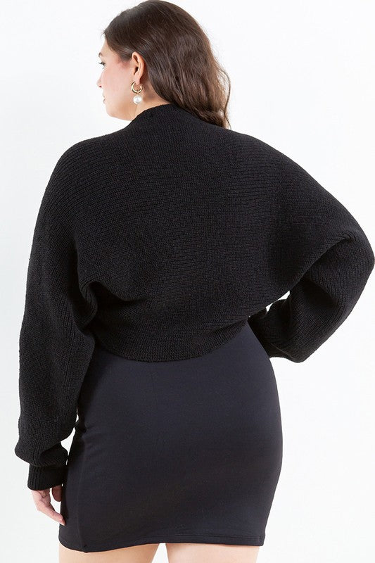 Woman wearing a black cardigan over a black dress on a white background