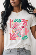 Person wearing a white t-shirt with colorful floral and cactus design.