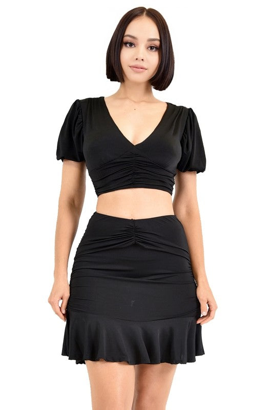Woman wearing a black top and skirt set on a white background