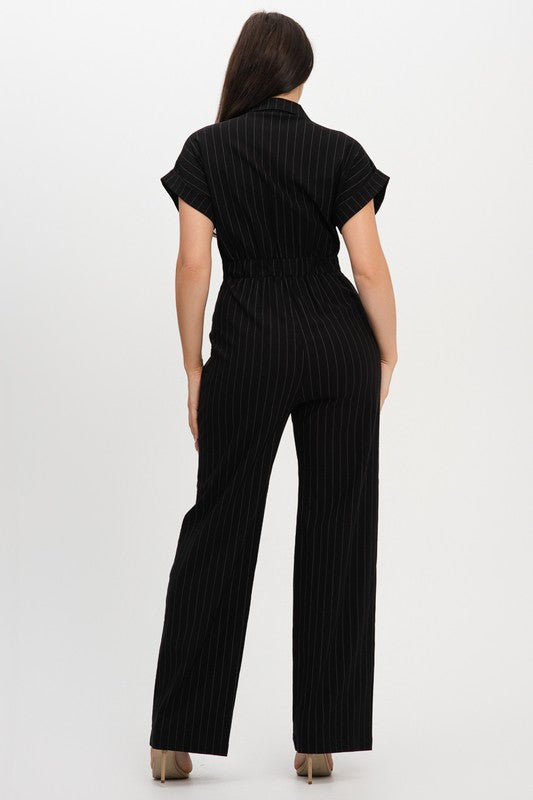 Woman wearing a black pinstripe jumpsuit on a white background