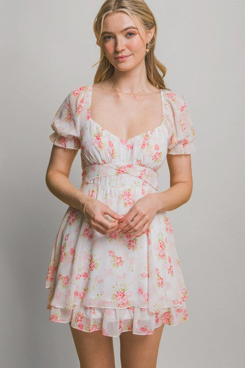 Woman wearing a floral dress against a plain background