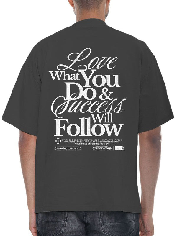 Black t-shirt with motivational quote on the back, worn by a person.