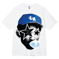 White t-shirt with graphic design of a person wearing a blue cap and stars, on a white background.