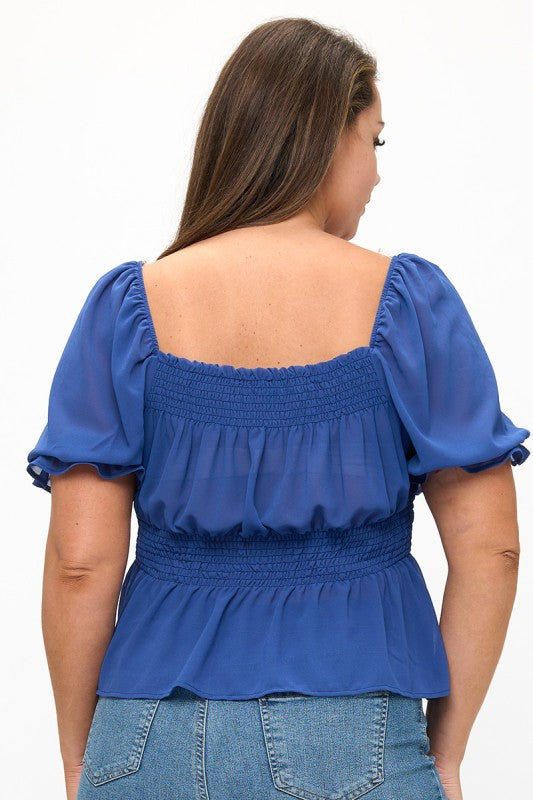 Woman wearing a blue blouse with puffed sleeves on a white background