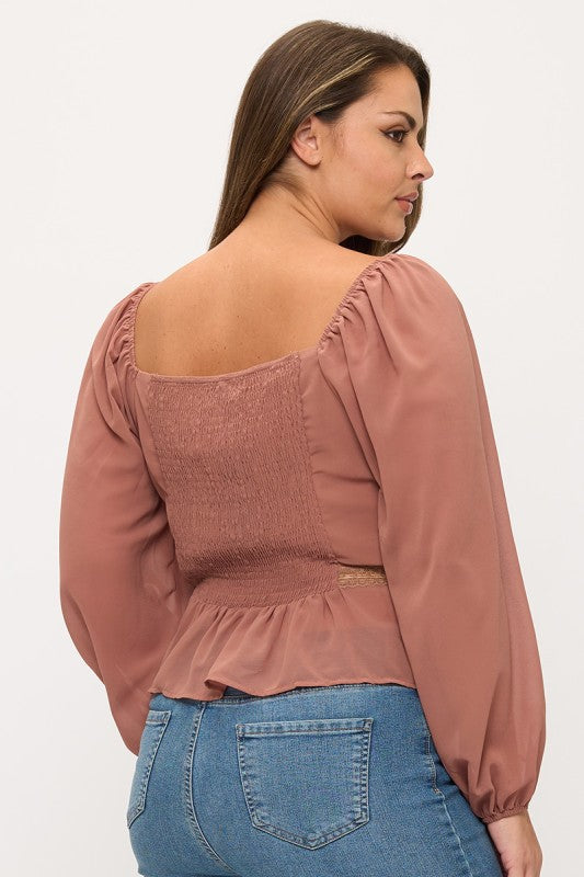 Woman wearing a pink blouse with long sleeves and a white background