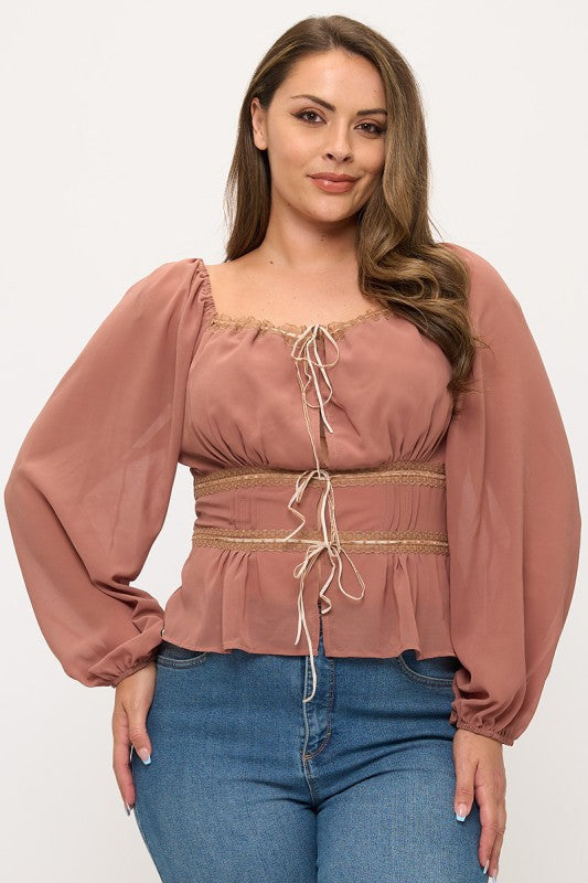 Woman wearing a pink blouse with long sleeves and blue jeans on a white background