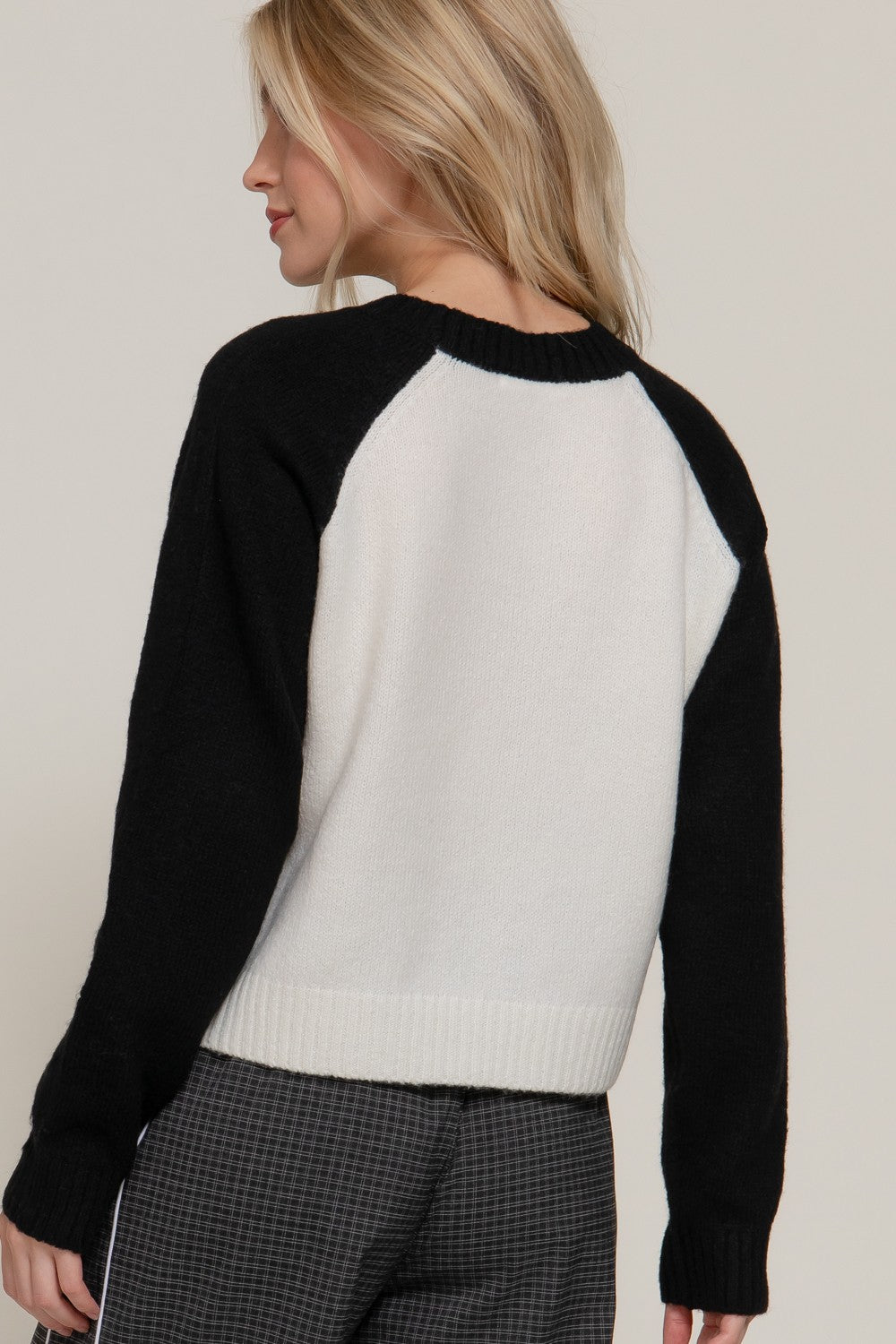 Close-up of a black-and-white knit sweater featuring “Brooklyn 76 United States” lettering and a bold number 76 graphic.