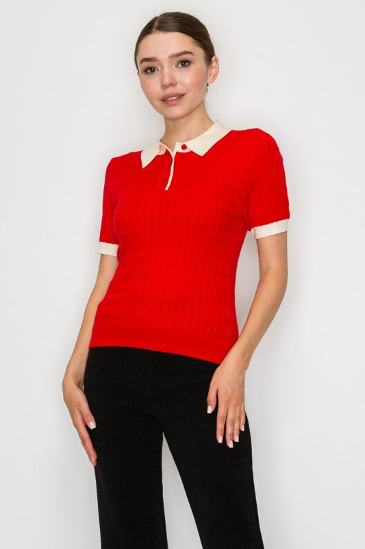 Woman wearing a red sweater with a white collar against a plain background