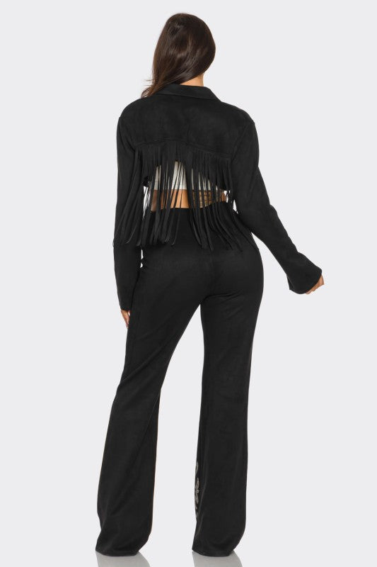 Person wearing a black outfit with fringe details on a white background