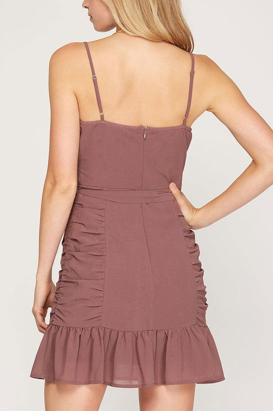Mauve dress with ruched details on a plain background