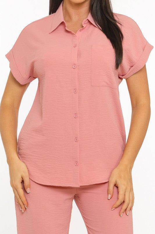 Woman wearing a pink short-sleeve shirt and pants on a white background