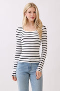 Woman wearing a black and white striped long-sleeve top and light blue jeans on a white background