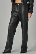 Black leather pants worn by a person on a gray background
