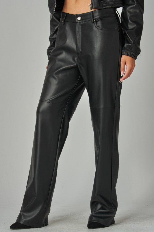 Black leather pants worn by a person on a gray background