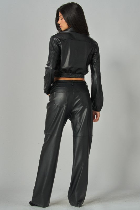 Person wearing a black leather outfit on a gray background